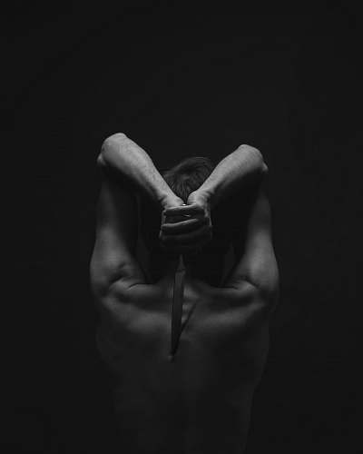 hand grayscale photography of person holding knife black-and-white
