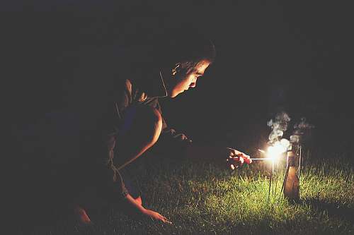 fire man crouching holding sparkler light