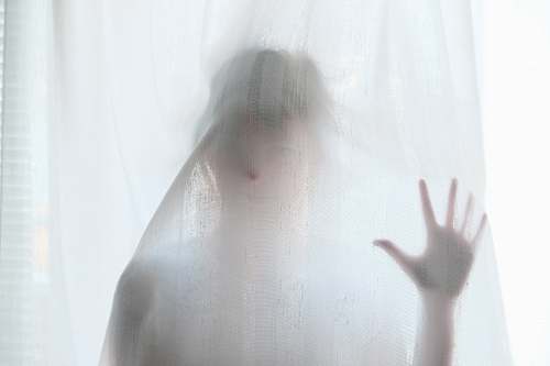 spooky woman holding behind curtain woman