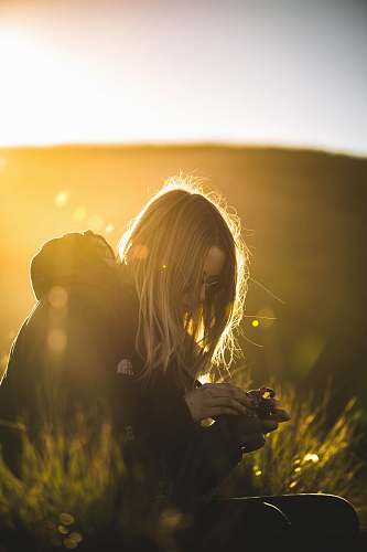 woman woman in black jacket holding black DSLR camera sunlight
