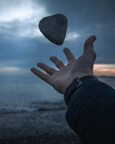 person person's hand throwing gray stone human