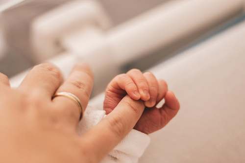 human baby holding mother's hand person