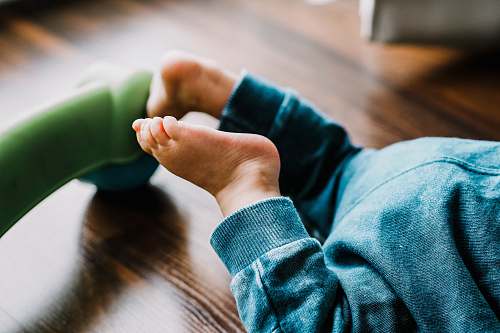 wood baby wearing blue pants hardwood