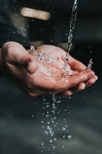 person clear liquid pouring on person's hands human