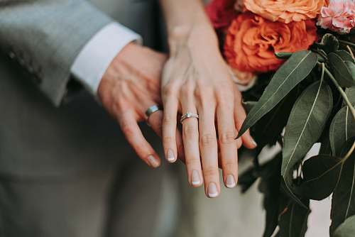 human couple wearing silver-colored rings flower