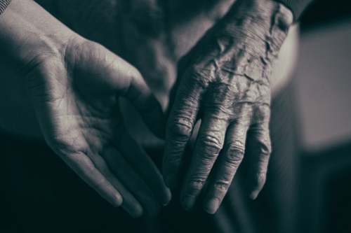 grey grayscale photo of two hands about to hold finger