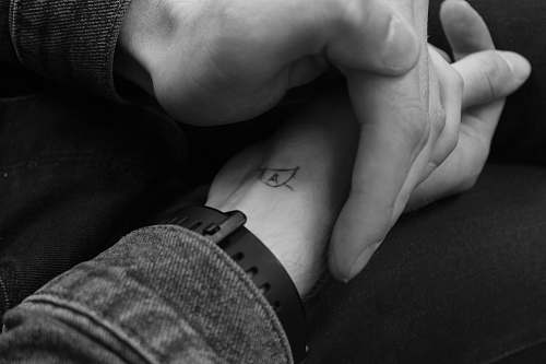 black-and-white grayscale photography of two hands holding skin