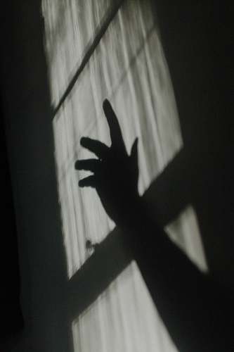 grey hand shadow on glass window finger