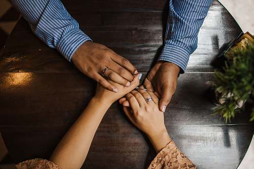 person hands holding on brown wooden table human