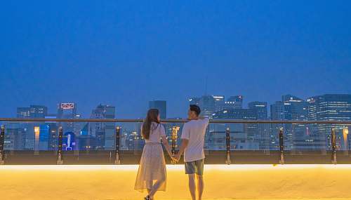 person man and woman holding hands near buildings human