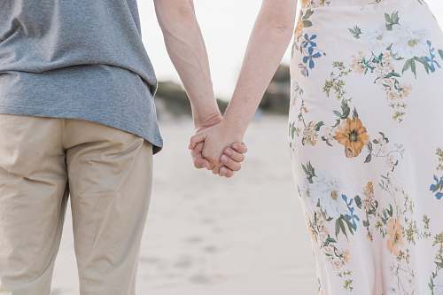 person man and woman holding hands on sand field human