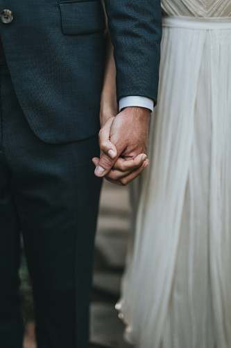 person man in suit holding hands with woman in white skirt human