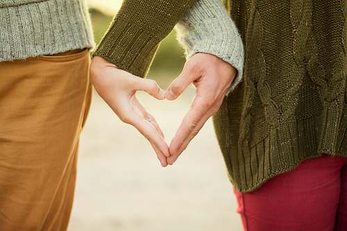 love person forming heart shape with their hands couple