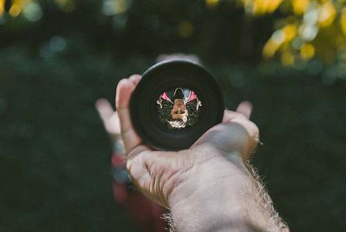 reflection person holding camera lens len