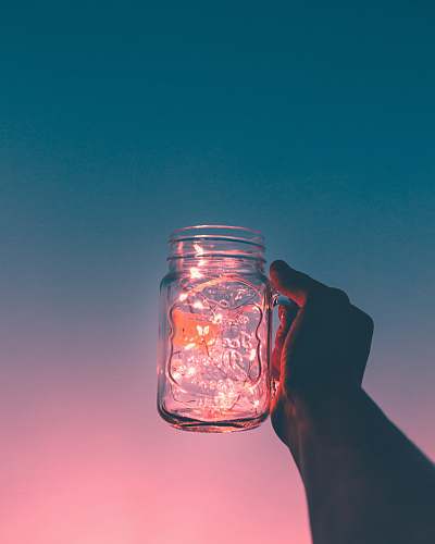 glass person holding clear glass mug jar pink