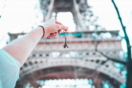 paris person holding Eiffel Tower keychain holding