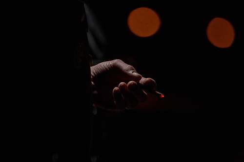 person person holding lighted single cigarette finger