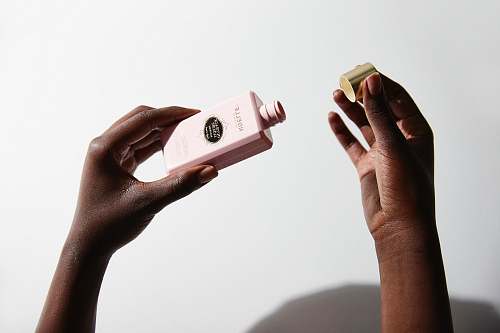 arm person holding makeup bottle cleansing