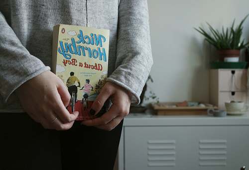 book person holding Nick Hornby's About a Boy book plant