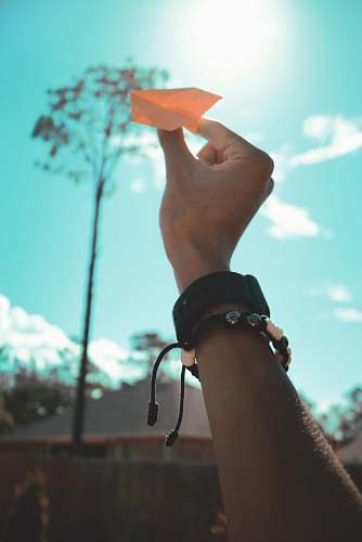 person person holding orange paper plane toy human