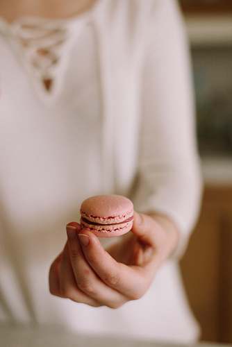 london person holding pink macaroon united kingdom