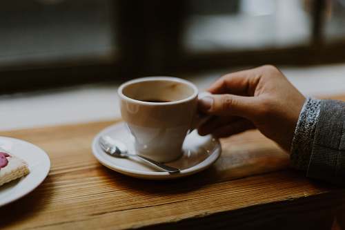 coffee person holding white ceramic tea cup cup