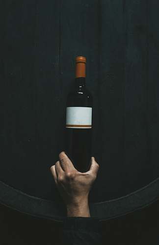 wine person holding white labeled bottle bottle