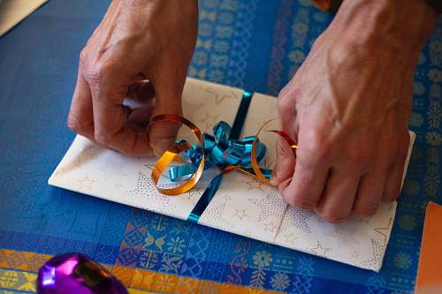 human person putting ribbon on card finger