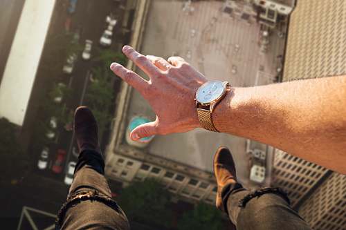 human person wearing round gold-colored watch wristwatch