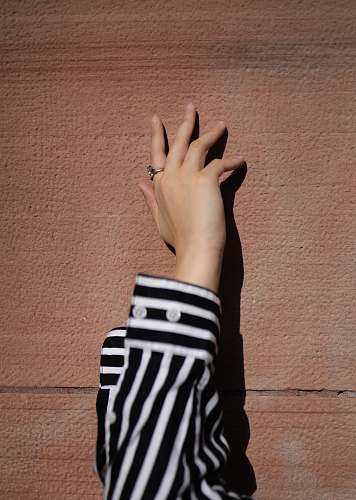 human person wearing white and black striped long-sleeved shirt wrist