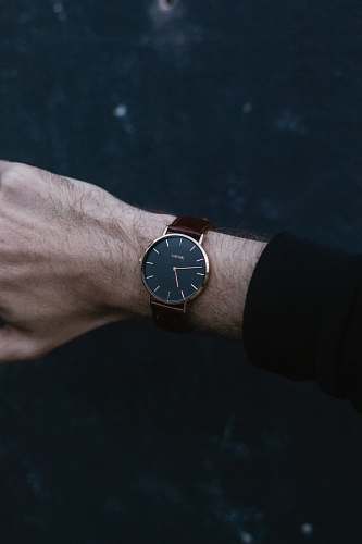 wristwatch person wears analog watch reading 06:47 wrist