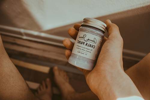 holding person's hand holding Chalk Paint bottle chalk paint