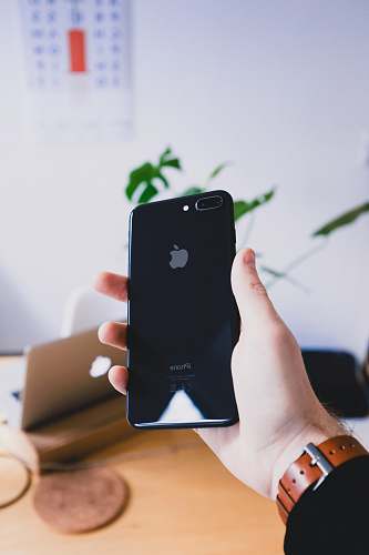 holding person's hand holding jet black iPhone 7 Plus mobile phone