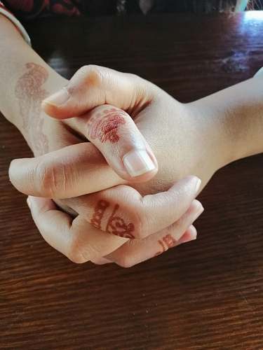 human person's hands with red mehndi tattoos person