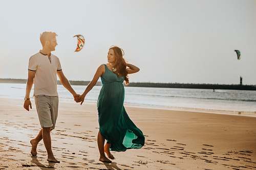 human pregnant woman and man walking on beach person