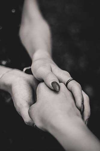 human selective focus of man and woman holding hands grey