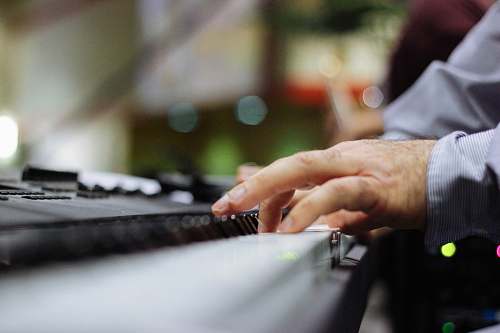 music selective focus of person playing piano jewelry