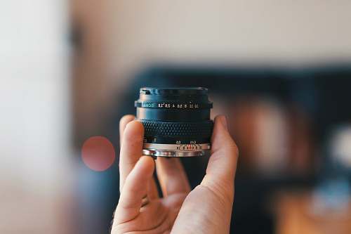camera selective focus photography of person holding camera lens electronics