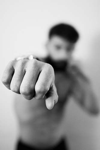 human topless man raising his fist black-and-white