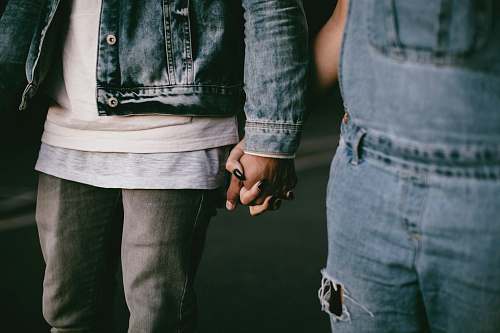 denim two person holding hands while walking jeans