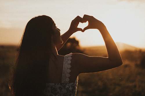 person woman forming heart with her both hands human