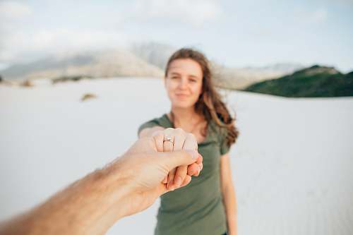 human woman wearing green top holding hand person