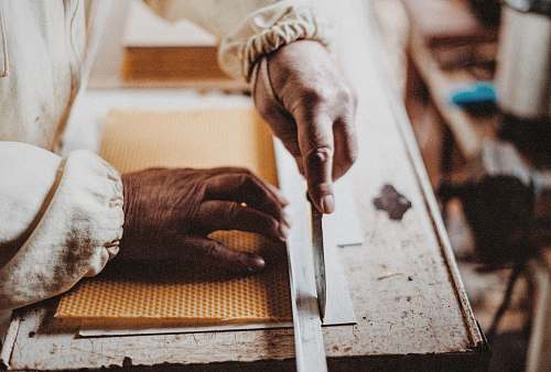 work person holding chisel while carving wood knife