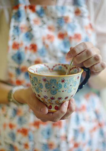 tea person holding multicolored ceramic teacup cup
