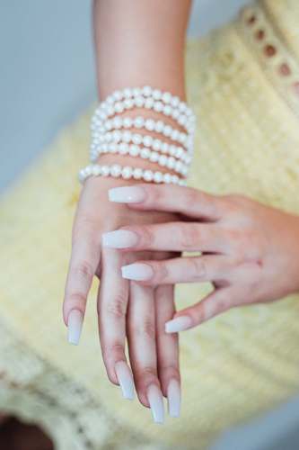 person beaded white bracelet finger