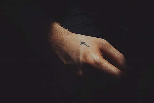 person black ink cross arm tattoo skin