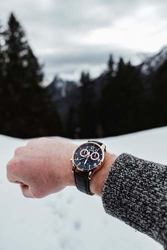 person chronograph watch reading 12:30 o'clock wrist