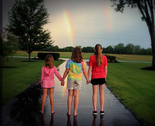 person girls standing near tree hand