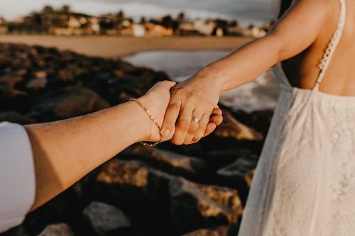 hand gold-colored bracelet holding hands