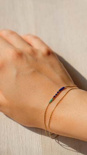 person gold-colored bracelet hand